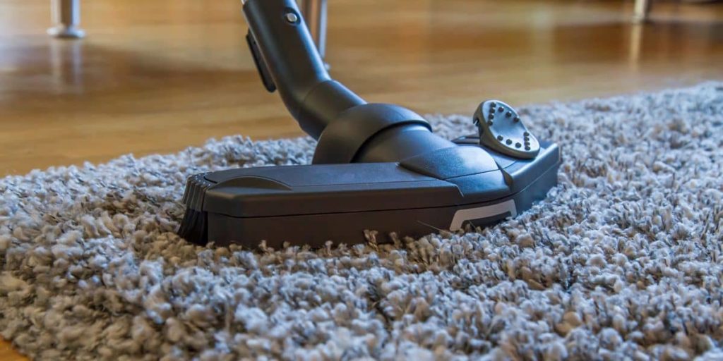A professional carpet cleaning device cleaning an area rug.